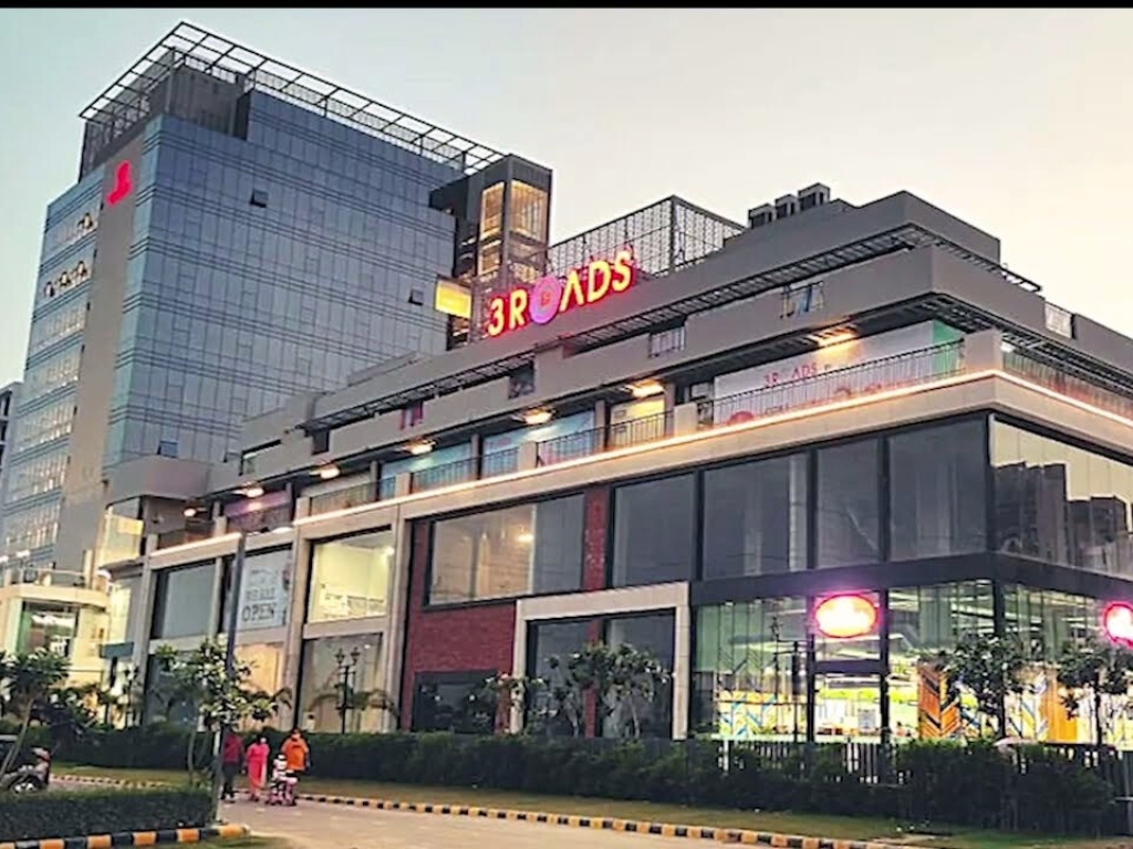 Reach 3 Roads Sector 70 vibrant evening retail frontage with modern high-street commercial spaces on SPR Road Gurugram
